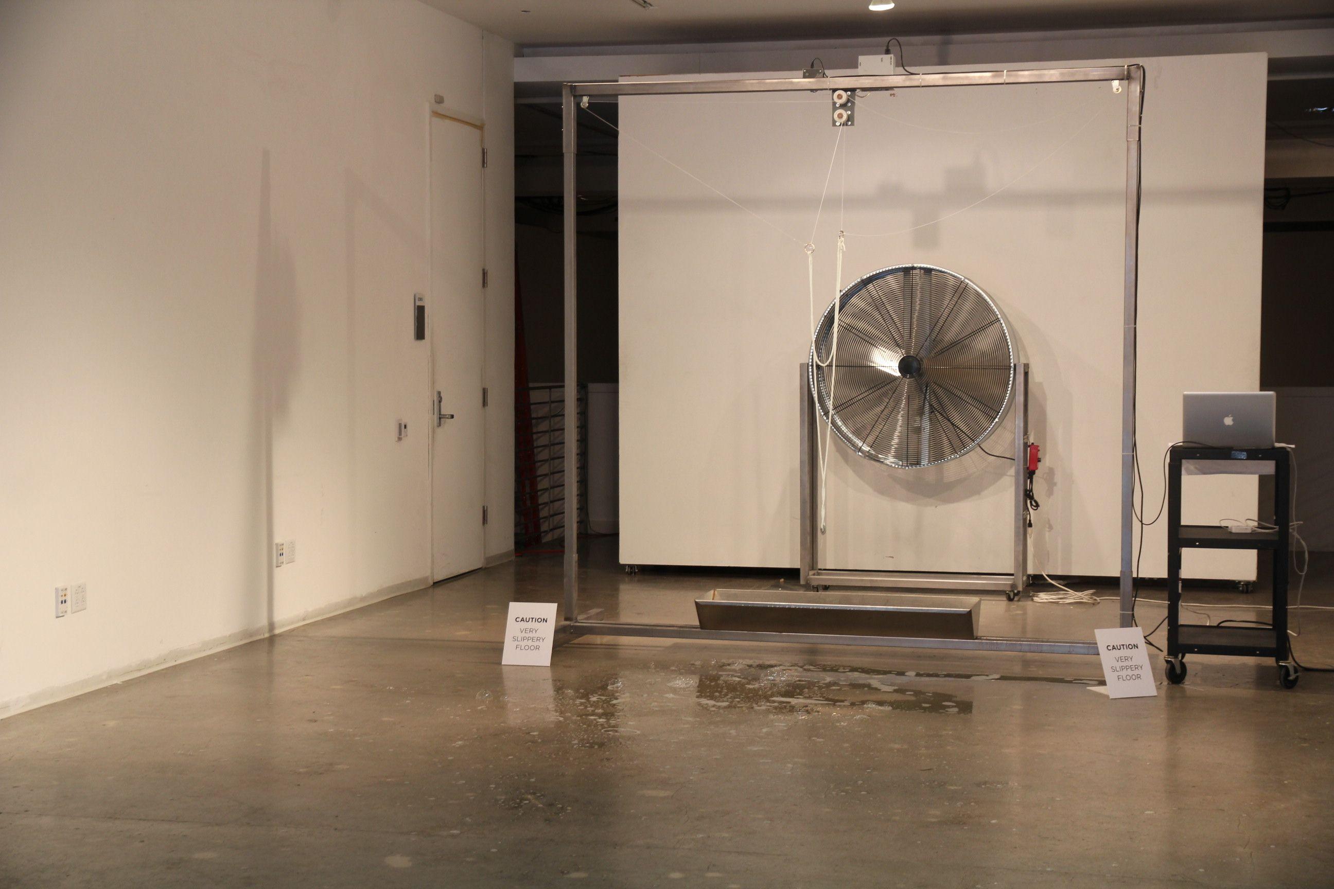 An art installation with a fan and computer.